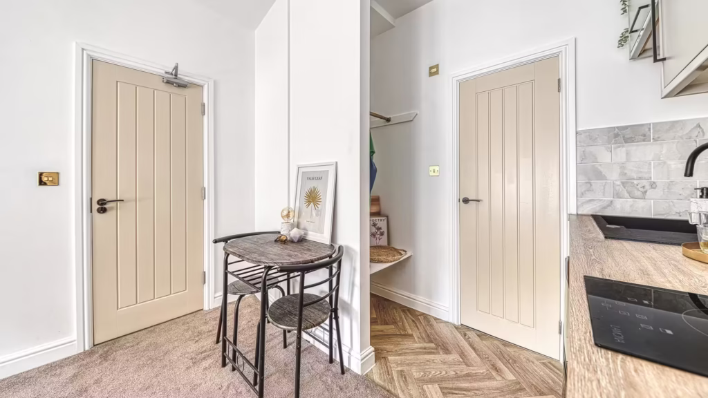 Small dining area between kitchen and hallway doors.