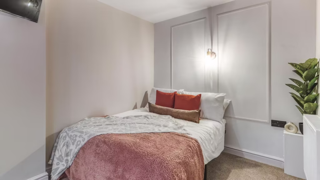 Cosy bedroom with double bed and wall lighting.