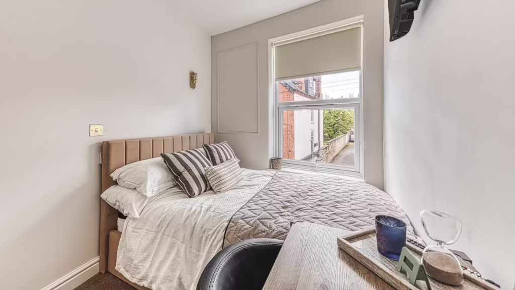 Cosy bedroom with window view and decorations.