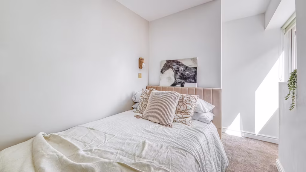 Modern bedroom with neutral decor and horse artwork.