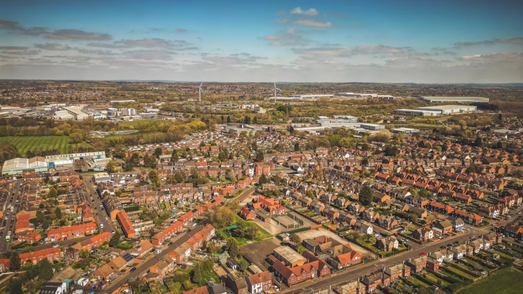 Aerial view of suburban houses and green fields.