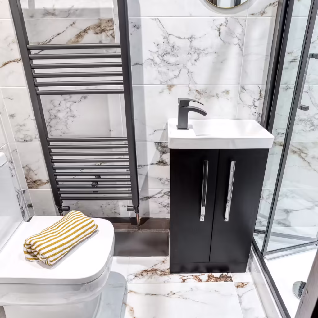 Modern bathroom with marble tiles and compact basin.