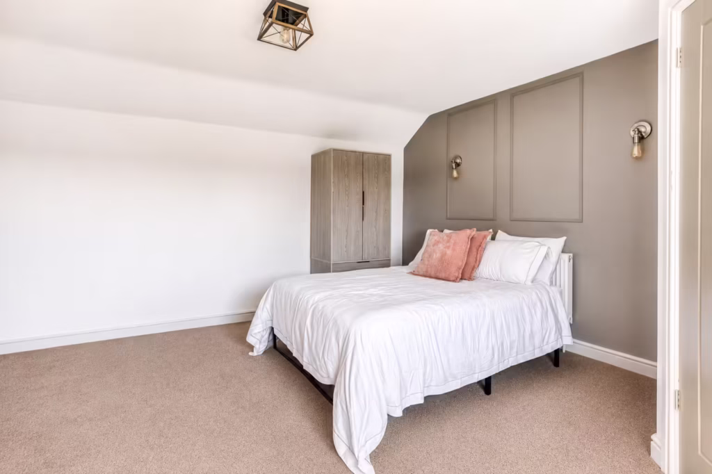 Minimalist bedroom with white bed and cushions